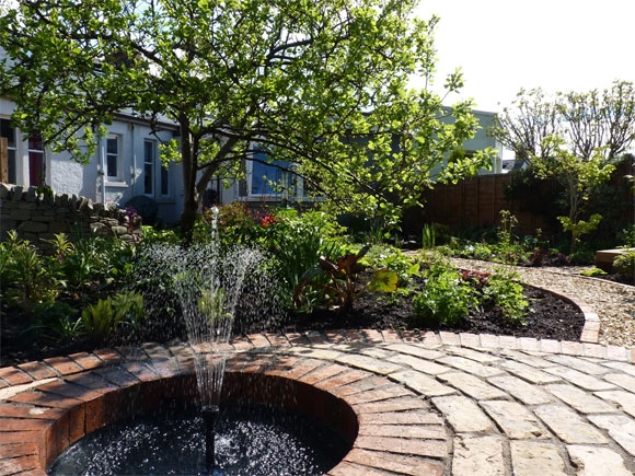 A beautiful water feature set into a patio creates a wonderful focal point at the end of the curving path