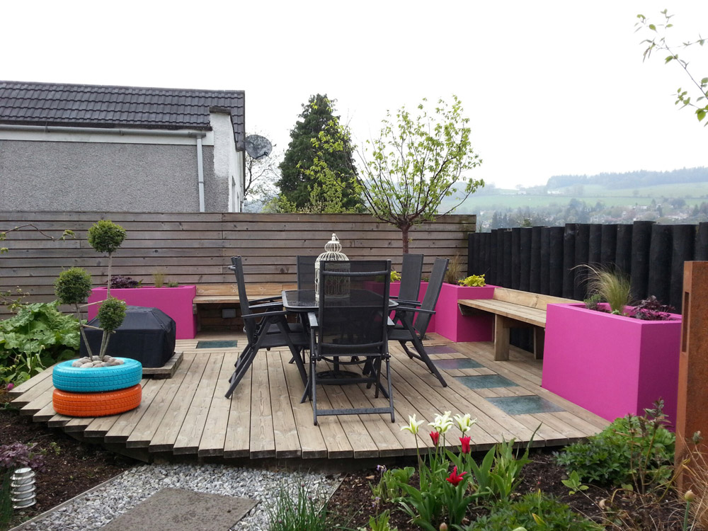 Bright pink, rendered raised beds provides planting space around the deck