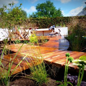 A contemporary boardwalk and bespoke deck with in-built seating in a garden in Bridge of Allan. Designed and built by Vialii