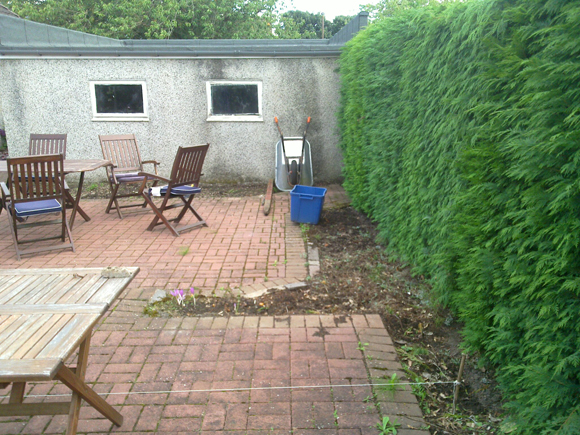 Before: an ugly garage wall and monoblocked patio