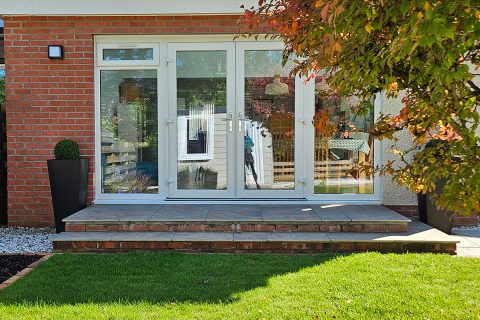 New black pots with box balls frame the patio doors